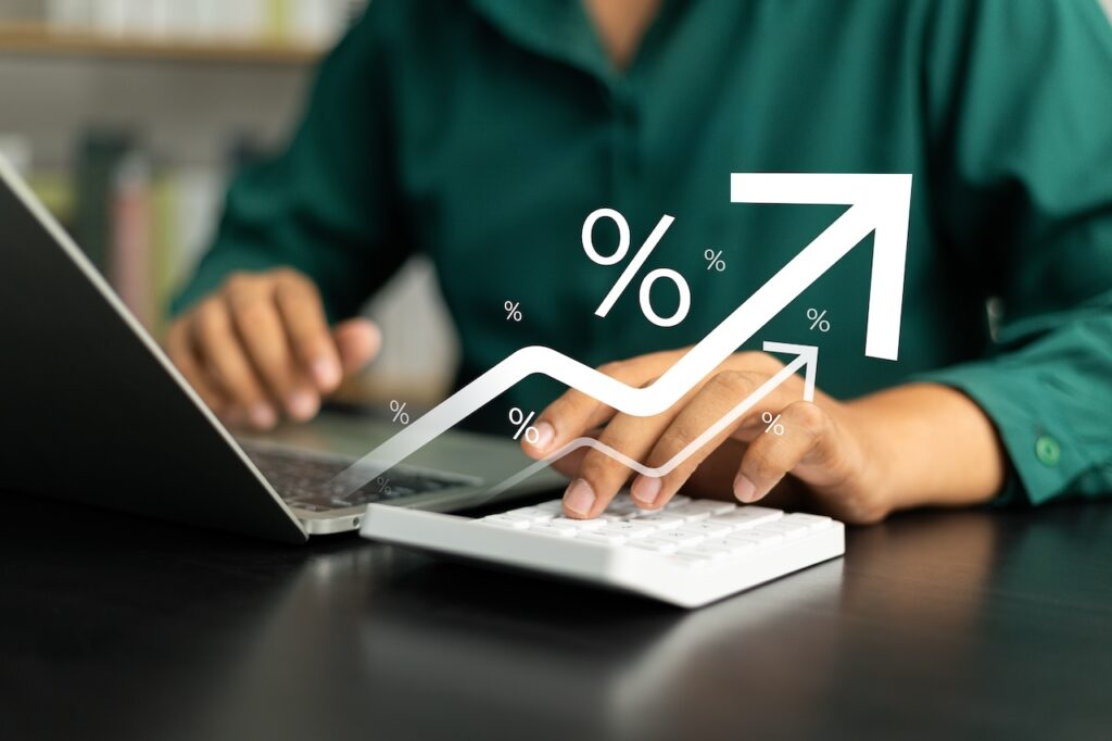 Interest Rate Concept, Business Man Using Calculator With Graph Percentage Symbol And Up Arrow, Growth Of Investments And Profits, Dividends And Long Term Investing To Win Inflation, Calculate Taxes.