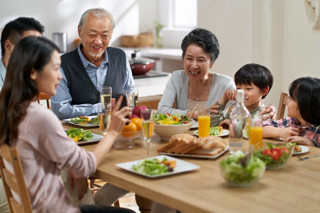 Familia asiática multigeneracional comiendo en casa