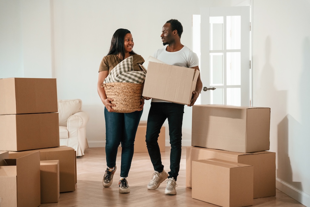 Walking In, Holding Boxes. African American Couple Are Moving Into New House